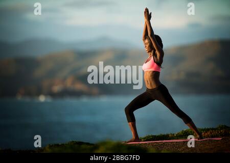 Junge Frau, die in einer Yoga in der Nähe der Küste dar. Stockfoto