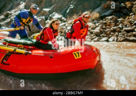 Eine Gruppe von Freunden, die Spaß haben, während sie gemeinsam Wildwasser-Rafting durch Stromschnellen in einem schnell fließenden Fluss Unternehmen. Stockfoto