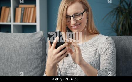 Fröhliche Blondine mit Smartphone Stockfoto