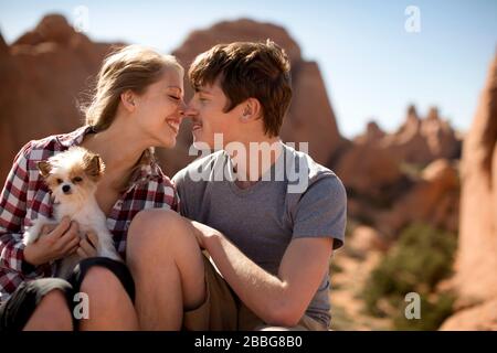 Glückliches junges Paar, das einen liebevollen Moment in der Wüste teilt Stockfoto