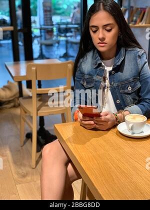 Mädchen mit einer Tasse Kaffee auf einem Holztisch im Café, Panama-Stadt, Mittelamerika Stockfoto