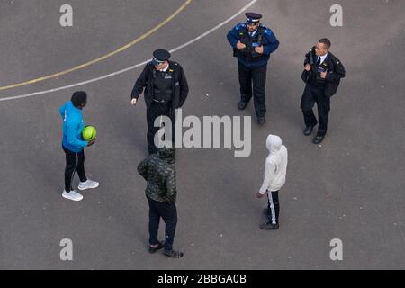 London, Großbritannien. März 2020. Coronavirus: Soziale Fernpolizei. Die Polizei im Südosten Londons rät einer Gruppe lokaler Teenager, sich von einem Fußballplatz zu lösen. Die Polizei setzt weiterhin die COVID-19-Sammelbeschränkungen durch, indem sie alle Gruppen, die größer als zwei sind, und diejenigen, die nicht sichtbar trainieren, verteilt. Der Polizei wurden außerdem zusätzliche Befugnisse zur Durchsetzung der Sperre eingeräumt, die auch die Ausstellung von Geldstrafen vor Ort umfassen kann. Credit: Guy Corbishley/Alamy Live News Stockfoto