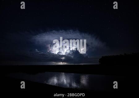 Sturm mit Wolkenbolken über Teich im ländlichen Kansas, Vereinigte Staaten Stockfoto