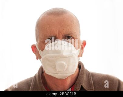 Älterer Mann, der eine Gesichtsmaske trägt. Nahaufnahme des Bildes mit Hochformat auf weißem Hintergrund. Stockfoto