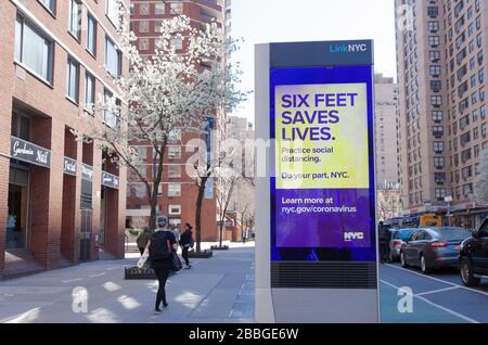 LinkNYC digitaler Kiosk auf dem Bürgersteig, der die Botschaft von Covid-19 (Coronavirus) anzeigt, um soziale Distanzierung zu üben. Stockfoto