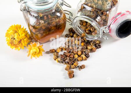 Alternative Arzneimischung aus Honig und Bienenbrot (fermentierte Blume und Pflanzenpollen von Honigbienen) im kleinen Glasbecher. Stockfoto