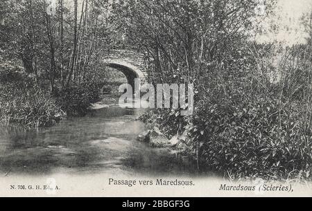 Postkarte aus den Jahren 1900 bis 1920, die eine kleine Gehwegbrücke über einen Bach in der Nähe der Maredsous-Abtei zeigt. Die Maredsous Abbey ist ein Kloster der Benediktion in Denée Stockfoto