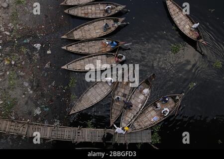 Dhaka, Bangladesch. März 2020. Ein Bootsmann passiert das Boot, da andere Bootsleute während der landesweiten Sperrung auf Passagiere warten, um die Ausbreitung von Coronavirus (COVID-19)-Epidemien am Ufer des Buriganga River zu verhindern. Kredit: MD Mehedi Hasan/ZUMA Wire/Alamy Live News Stockfoto