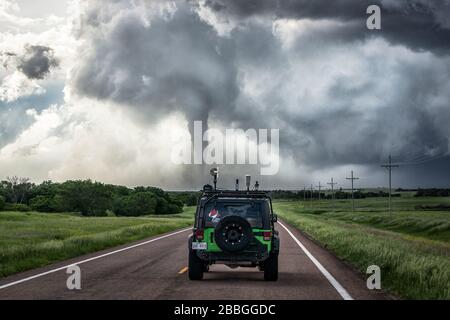 Tornado reißt Schmutz auf, während Jeep in Richtung des Trümmerfeldes in der Nähe von Hays Kansas United States fährt Stockfoto