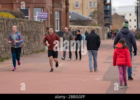 Edinburgh, Schottland, Großbritannien. März 2020. Trotz Coronavirus Lockdown sind die Mitglieder der Öffentlichkeit auf der Portobello-Promenade in Edinburgh draußen beim Trainieren und Entspannen. Iain Masterton/Alamy Live News Stockfoto