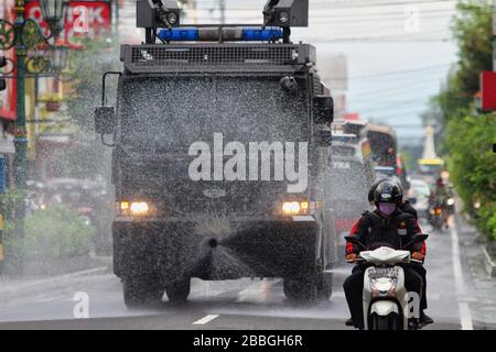 Sonderregion Yogyakarta, Indonesien. März 2020. Polizisten sprühen mit taktischen Fahrzeugen Desinfektionsmittel, um das Corona-Virus am Tugu Pal Putih Monument, einer der Tourismus-Ikonen von Yogyakarta, Dienstag, 31. März 2020 zu töten. Die indonesische Regierung hat noch keinen Lockdown verhängt, um die Ausbreitung des Corona-Virus zu verhindern, obwohl tausend Einwohner positiv für die Corona-Krankheit sind. (Foto von Devi Rahman/INA Photo Agency/Sipa USA) Credit: SIPA USA/Alamy Live News Stockfoto