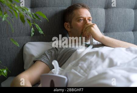 Kranker Mann mit Inhalatormaske auf dem Gesicht im Bett. Konzept zur Vorbeugung von Coronavirus. Stockfoto