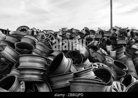 Berge von Autofelgen türmten sich in einem Schrottplatz auf. Stockfoto