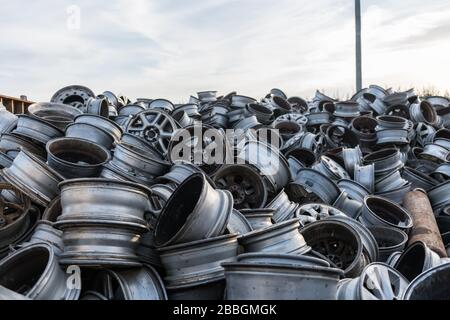 Berge von Autofelgen türmten sich in einem Schrottplatz auf. Stockfoto