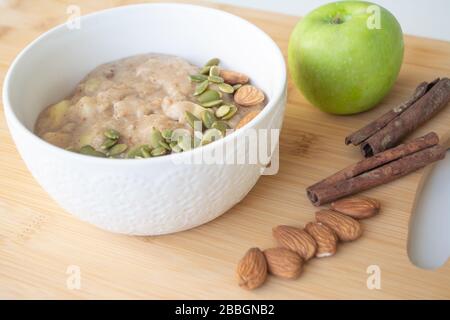 Gesundes Frühstück: Haferbrei mit Zimt, apfel und Banane mit Mandeln und Kürbiskernen Stockfoto