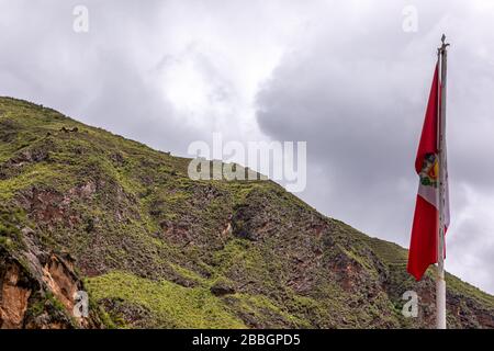 Nahaufnahme der Nationalflaggen Perus mit einigen inka-ruinen von Pisac (Heilig Tal) im Hintergrund (oben auf dem Berg). Stockfoto