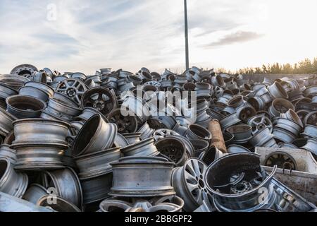 Berge von Autofelgen türmten sich in einem Schrottplatz auf. Stockfoto