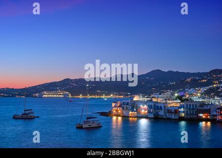 Sonnenuntergang in Mykonos, Griechenland, mit Kreuzfahrtschiff und Yachten im Hafen Stockfoto