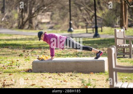 Berks County, Pennsylvania, USA-22. März 2020: Fit Young Woman, die Planken oder Push-Ups im Freien im öffentlichen Park macht. Stockfoto