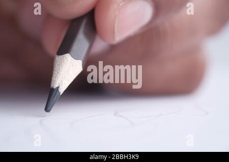 Nahaufnahme der männlichen Hand mit Bleistift auf Papier Stockfoto