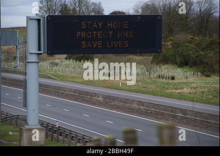 Cumbernauld, Schottland, Großbritannien. März 2020. Abbildung: Autobahnschilder zeigen die Meldung "BLEIB ZU HAUSE SCHUTZ NHS LEBEN RETTEN" während der britischen Sperrzeit, um die Verbreitung des Coronavirus zu stoppen, in dem 1.993 Menschen jetzt positiv auf den Virus getestet haben und 60 Menschen an dem Virus gestorben sind. Kredit: Colin Fisher/Alamy Live News Credit: Colin Fisher/Alamy Live News Stockfoto