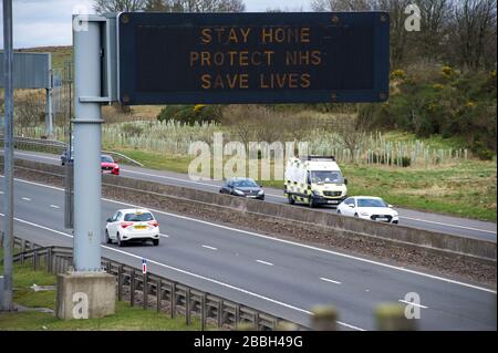 Cumbernauld, Schottland, Großbritannien. März 2020. Abbildung: Autobahnschilder zeigen die Meldung "BLEIB ZU HAUSE SCHUTZ NHS LEBEN RETTEN" während der britischen Sperrzeit, um die Verbreitung des Coronavirus zu stoppen, in dem 1.993 Menschen jetzt positiv auf den Virus getestet haben und 60 Menschen an dem Virus gestorben sind. Kredit: Colin Fisher/Alamy Live News Credit: Colin Fisher/Alamy Live News Stockfoto