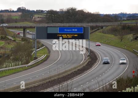 Cumbernauld, Schottland, Großbritannien. März 2020. Abbildung: Autobahnschilder zeigen die Meldung "BLEIB ZU HAUSE SCHUTZ NHS LEBEN RETTEN" während der britischen Sperrzeit, um die Verbreitung des Coronavirus zu stoppen, in dem 1.993 Menschen jetzt positiv auf den Virus getestet haben und 60 Menschen an dem Virus gestorben sind. Kredit: Colin Fisher/Alamy Live News Credit: Colin Fisher/Alamy Live News Stockfoto