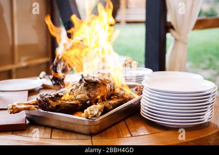 Kochshow bereitet der Koch in einer Bratpfanne mit Feuer Speisen zu. Der Küchenchef bereitet im Restaurant Speisen mit einer Feuershow zu. Stockfoto
