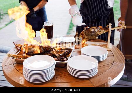 Kochshow bereitet der Koch in einer Bratpfanne mit Feuer Speisen zu. Der Küchenchef bereitet im Restaurant Speisen mit einer Feuershow zu. Stockfoto