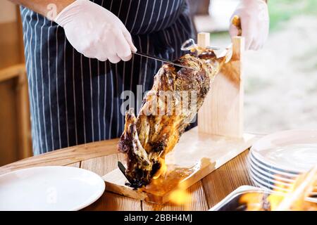 Kochshow bereitet der Koch in einer Bratpfanne mit Feuer Speisen zu. Der Küchenchef bereitet im Restaurant Speisen mit einer Feuershow zu. Stockfoto