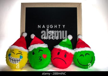 Ein Schwarz-Weiß-Schild mit einem Birch-Rahmen, das Naughty oder Nice mit Holiday Emoticons vor sich sagt Stockfoto