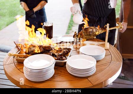 Kochshow bereitet der Koch in einer Bratpfanne mit Feuer Speisen zu. Der Küchenchef bereitet im Restaurant Speisen mit einer Feuershow zu. Stockfoto