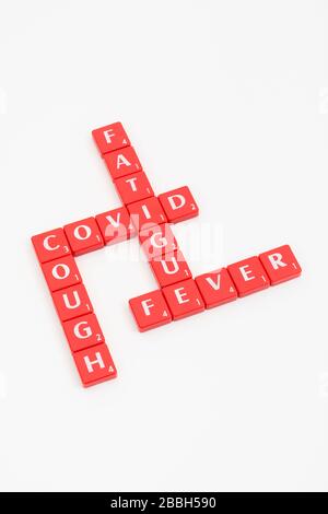 Buchstabenkacheln, die frühe Coronavirus / Covid-19 CV19 Symptome: Müdigkeit, Husten, Fieber / hohe Temperatur. Später gibt es Schwierigkeiten beim Atmen Stockfoto