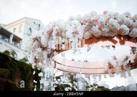 Ein wunderbarer Ort in den Dekorationen und Blumen für die Hochzeitsfeier. Mit transparenten Stühlen am Meer. Stockfoto