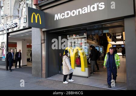 McDonalds, das jetzt als Sit Down fast Food-Restaurant geschlossen ist, ist noch offen für Bestellungen in der Oxford Street, Londons Haupteinkaufs- und Einzelhandelsgebiet, die normalerweise voller Tausende von Käufern sind und der Verkehr aufgrund des Coronavirus Ausbruchs am 23. März 2020 in London, England, praktisch verlassen ist. Großbritannien. Die meisten Käufer sind nach Regierungsratschlägen zu Hause und verlassen die Straßen ruhig, leer und unheimlich. Coronavirus oder Covid-19 ist eine neue Atemwegserkrankung, die beim Menschen bisher nicht beobachtet wurde. Während ein Großteil oder Europa in den Sperrstand versetzt wurde, hat die britische Regierung angekündigt Stockfoto