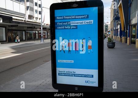 HM Government und NHS Advertising Boards Rat für die Beantragung von Universal Credit in der Innenstadt von Birmingham ist aufgrund des Coronavirus Ausbruchs am 31. März 2020 in Birmingham, England, Großbritannien praktisch desertiert. Nach Regierungsraten bleiben die meisten Menschen zu Hause und verlassen die Straßen ruhig, leer und unheimlich. Coronavirus oder Covid-19 ist eine neue Atemwegserkrankung, die beim Menschen bisher nicht beobachtet wurde. Während ein Großteil oder Europa in die Blockierung versetzt wurde, hat die britische Regierung strengere Regeln als Teil ihrer langfristigen Strategie und insbesondere ihrer sozialen Distanzierung angekündigt. Stockfoto