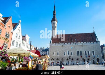 TALLINN, ESTLAND - 14. JULI 2019: Zentraler Platz touristisches Ziel der Altstadt mit Cafés und Restaurants dekoriert mit Blumen, Kirche in hellen Farben Stockfoto