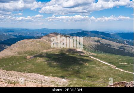Landschaft mit grünen Wiesen und Berghängen mit massivem Blick auf Denver vom Mount Evans Scenic Byway in Colorado Stockfoto