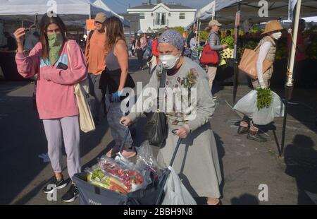 Die Marktkäufer der Farmer können keine soziale Distanzierung von 6' beibehalten, die auf den Schildern auf dem Larchmont Village Market in Los Angeles am Sonntag, 29. März 2020 empfohlen wird. Bürgermeister Eric Garcetti sagte in seinen fortgesetzten Bemühungen, die Menschenmassen inmitten des städtischen und landesweiten Aufenthalts zu Hause zu kontrollieren, dass die Bauernmärkte vorübergehend geschlossen werden und nur dann wieder geöffnet werden dürfen, wenn sie einen Plan vorlegen, der zeigt, wie Menschenmassen kontrolliert werden können. Garcetti sagte, dass dies unter anderem bedeuten könnte, dass man einen einzigen Eintrag und einen einzigen Ausstieg verlangen muss. Dateifoto von Jim Ruymen/UPI Stockfoto