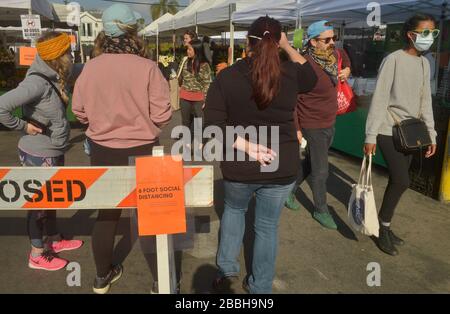 Die Marktkäufer der Farmer können keine soziale Distanzierung von 6' beibehalten, die auf den Schildern auf dem Larchmont Village Market in Los Angeles am Sonntag, 29. März 2020 empfohlen wird. Bürgermeister Eric Garcetti sagte in seinen fortgesetzten Bemühungen, die Menschenmassen inmitten des städtischen und landesweiten Aufenthalts zu Hause zu kontrollieren, dass die Bauernmärkte vorübergehend geschlossen werden und nur dann wieder geöffnet werden dürfen, wenn sie einen Plan vorlegen, der zeigt, wie Menschenmassen kontrolliert werden können. Garcetti sagte, dass dies unter anderem bedeuten könnte, dass man einen einzigen Eintrag und einen einzigen Ausstieg verlangen muss. Dateifoto von Jim Ruymen/UPI Stockfoto