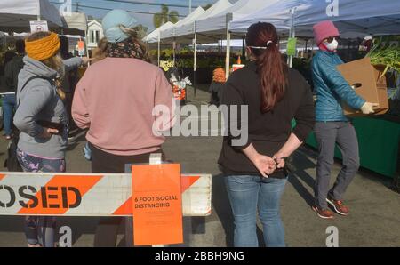 Die Marktkäufer der Farmer können keine soziale Distanzierung von 6' beibehalten, die auf den Schildern auf dem Larchmont Village Market in Los Angeles am Sonntag, 29. März 2020 empfohlen wird. Bürgermeister Eric Garcetti sagte in seinen fortgesetzten Bemühungen, die Menschenmassen inmitten des städtischen und landesweiten Aufenthalts zu Hause zu kontrollieren, dass die Bauernmärkte vorübergehend geschlossen werden und nur dann wieder geöffnet werden dürfen, wenn sie einen Plan vorlegen, der zeigt, wie Menschenmassen kontrolliert werden können. Garcetti sagte, dass dies unter anderem bedeuten könnte, dass man einen einzigen Eintrag und einen einzigen Ausstieg verlangen muss. Dateifoto von Jim Ruymen/UPI Stockfoto