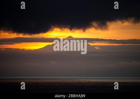 Las Palmas, Gran Canaria, Kanarische Inseln, Spanien. März 2020. Blick über den Atlantik von Gran Canaria aus, während die Sonne hinter Spaniens höchstem Berg, dem Berg Teide, auf dem ca. 50 km entfernten Flughafen von Teneras untergeht. Kredit: Alan Dawson/Alamy Live News Stockfoto