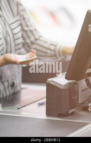 Nahaufnahme eines Kassierers hinter dem Kassenmonitor Stockfoto