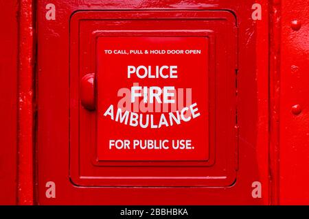 Detail eines alten öffentlichen Telefonkastens mit einem Polizei-, Feuer- und Krankenwagen-Schild, Glasgow, Schottland, Großbritannien Stockfoto