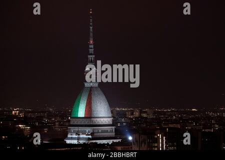 Turin, Italien. März 2020. TURIN, ITALIEN - 31. März 2020: Die Mole Antonellana, die wichtigste Sehenswürdigkeit in Turin, wird mit den Farben der italienischen Nationalflaggen beleuchtet, um Solidarität, Zusammenhalt und Heimatgefühl während der COVID-19-Notaufnahme auszudrücken. Die italienische Regierung hat beispiellose Einschränkungen auferlegt, um die Ausbreitung des COVID-19-Coronavirus-Ausbruchs zu stoppen, und andere Maßnahmen, die die Bewegungen der Menschen nur für die Arbeit, für den Kauf wesentlicher Waren und aus gesundheitlichen Gründen erlaubt sind. (Foto von Nicolò Campo/Sipa USA) Credit: SIPA USA/Alamy Live News Stockfoto