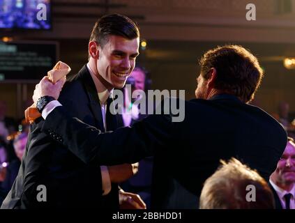 Der Gareth Bale von Tottenham Hotspur schüttelt mit seinem Manager Andre Villas Boas die Hände, während er beim PFA Player of the Year Award 2013 im Grosvenor House Hotel in London seine Auszeichnung abholt. Stockfoto