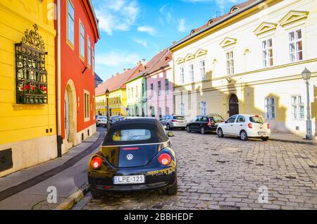 Budapest, Ungarn - 6. November 2019: Schöne historische Straße mit bunten Häusern im historischen Zentrum. Parken Sie Autos auf der gepflasterten Straße. Altstadt der ungarischen Hauptstadt. Bunte Fassaden. Stockfoto