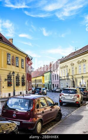 Budapest, Ungarn - 6. November 2019: Schöne historische Straße mit bunten Häusern im historischen Zentrum. Geparkte Autos auf der gepflasterten Straße. Altstadt der ungarischen Hauptstadt. Vertikales Foto. Stockfoto