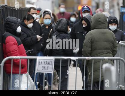 Brooklyn, Vereinigte Staaten. März 2020. Menschen, die Schutzmasken tragen, warten online, um am Dienstag, 31. März 2020 in New York City auf Coronavirus im Elmhurst Hospital Center getestet zu werden. New Yorks Fälle haben 75.000 und 1.550 Menschen starben. Foto von John Angelillo/UPI Credit: UPI/Alamy Live News Stockfoto