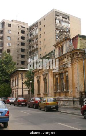 Das kommunistische Apartmentgebäude wurde in der Nähe von jahrhundertealten Villen in Bukarest, Rumänien, erbaut Stockfoto